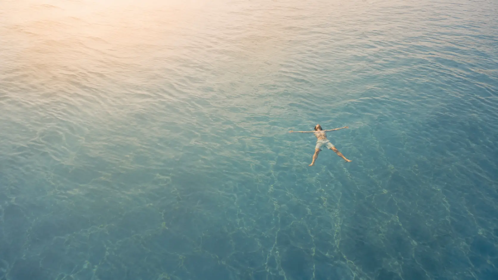 A person floating peacefully in clear blue water