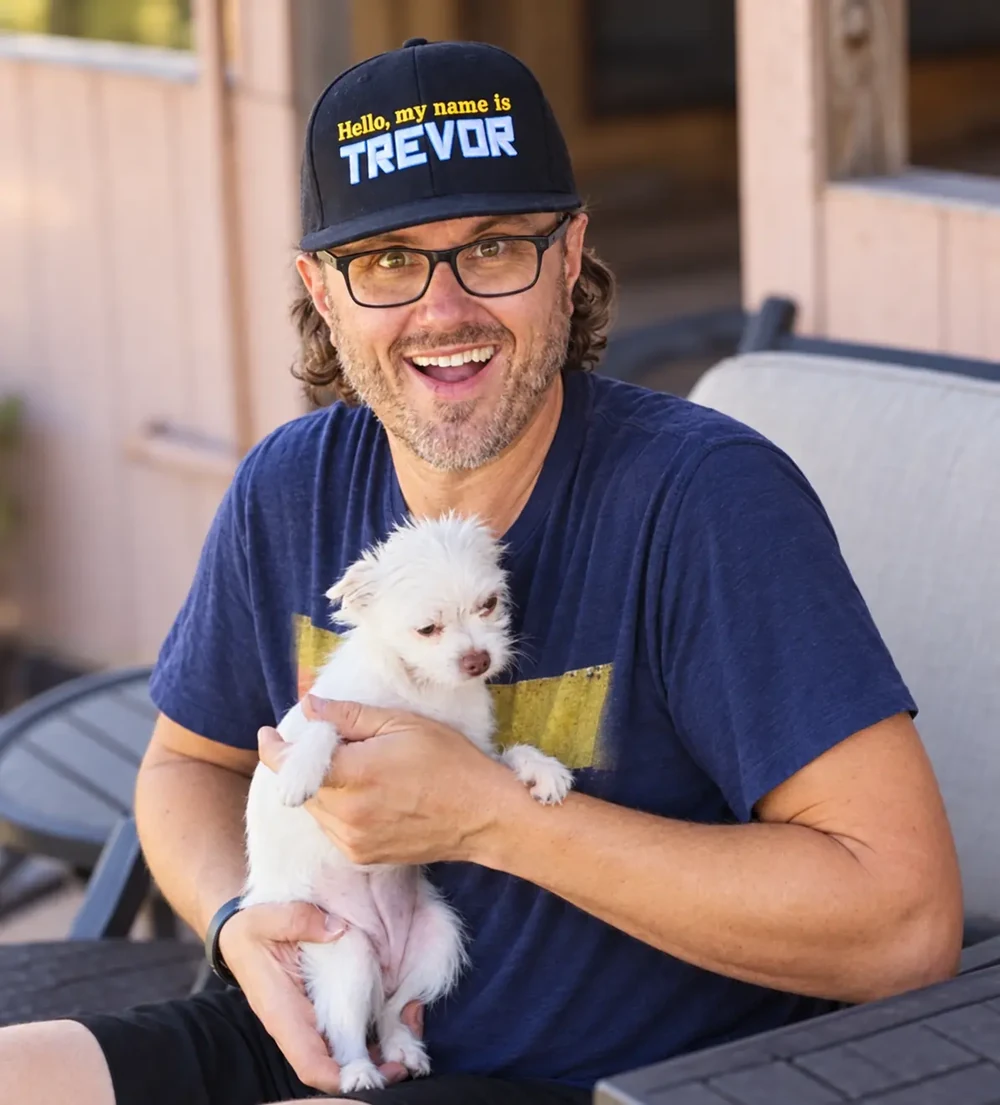 Trevor smiling while holding one of his dogs